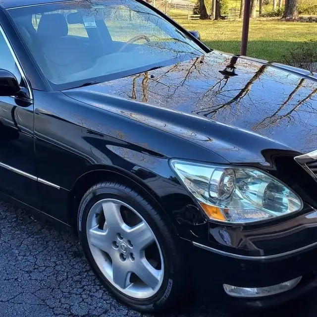 Black sedan with a freshly detailed, mirror-glossy hood and clean wheel