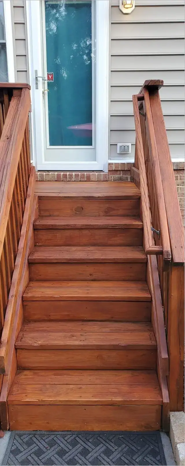 The same deck stairs washed and stained a deep red-brown